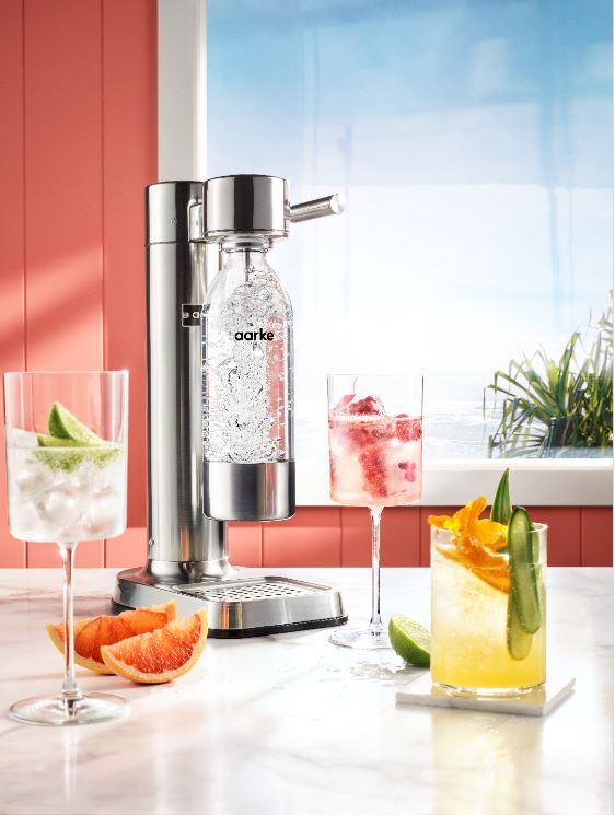 The Aarke Carbonator next to drinks in glasses.