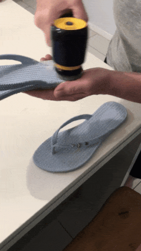 A person cleaning herringbone shoes with the Philips Sneaker Cleaner.