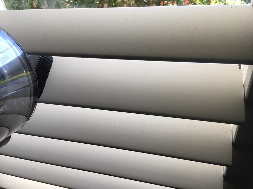 Plantation shutters that are in the process of being cleaned with the Dyson V11 Outsize Cordless Vacuum.