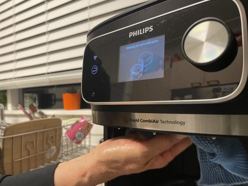A person cleaning the Philips 7000 XXXL Airfryer.