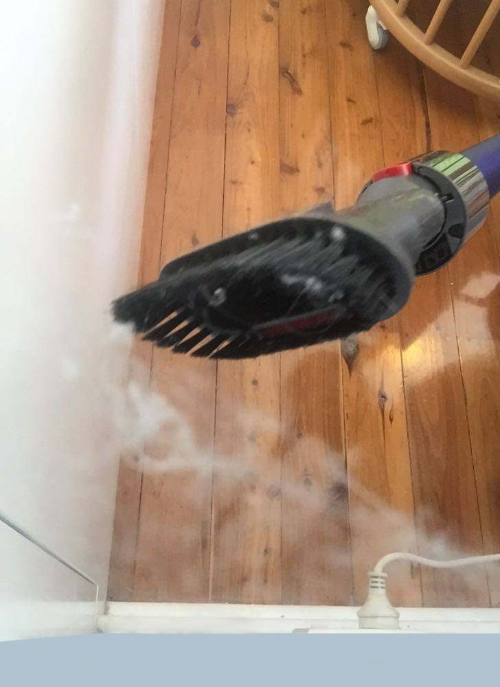 The Dyson V11 Absolute Extra about to vacuum an abandoned spider web in the corner of a room.