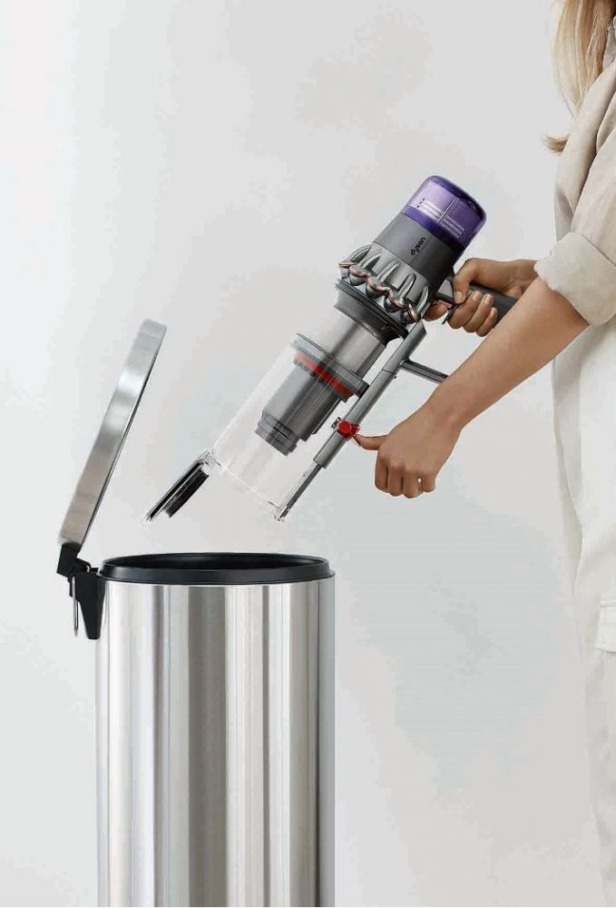 A person emptying the Dyson V11 Outsize Cordless Vacuum's large dustbin into the rubbish.