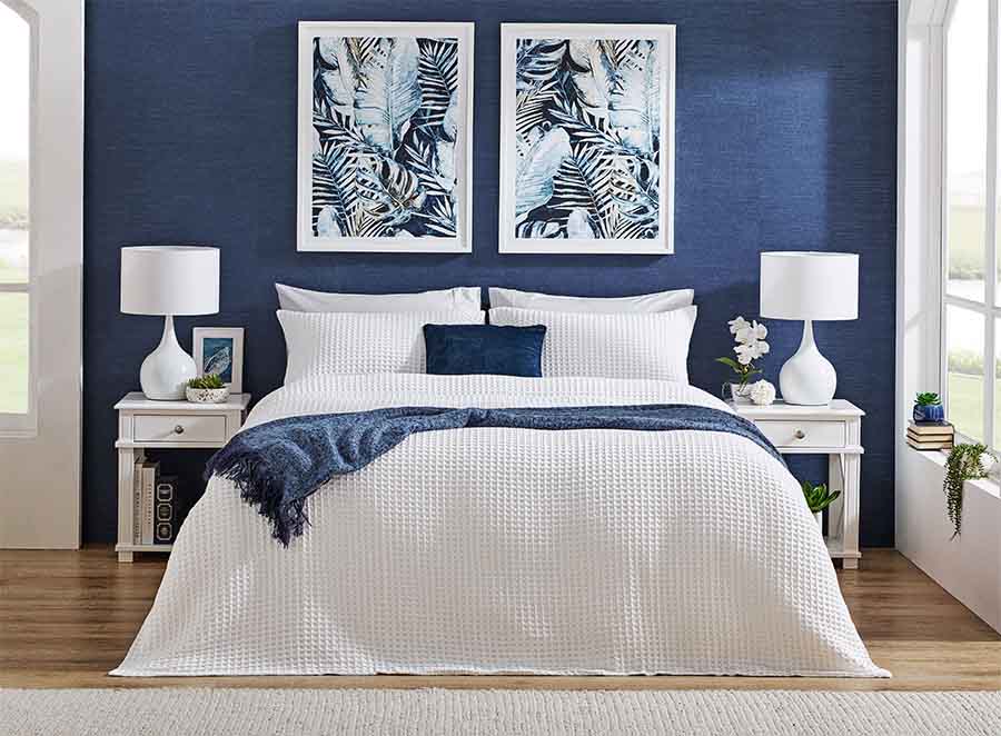 Easton Quilt Cover Set on a bed with a blue feature wall behind it.