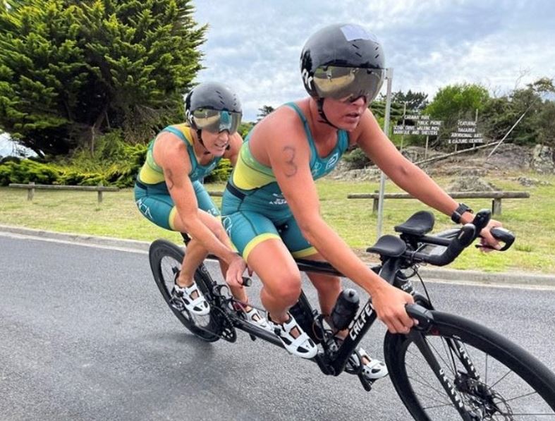Katie Kelly on a bike with her sighted guide.