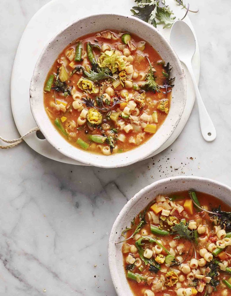 Two bowls of Minestrone with Pancetta, Zucchini Flowers and Baby Kale.