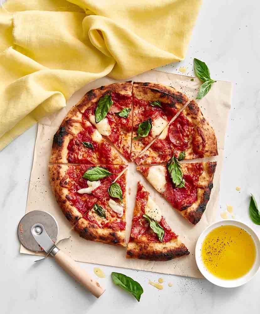 A sliced Napolitana Caprese Pizza.