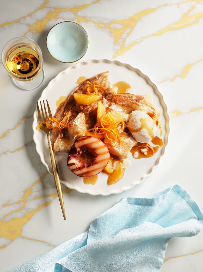 Orange crepe suzette with grilled seasonal stone fruit plate.