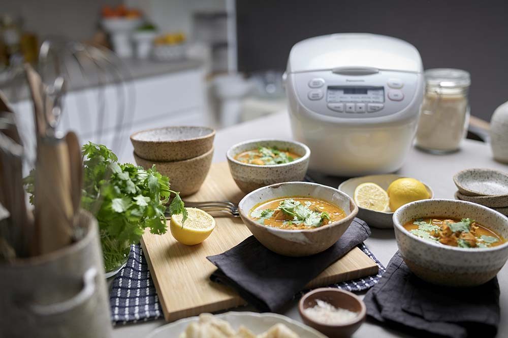 A feast of Kenyan Chicken Curry on a bench with the Panasonic Rice Cooker.
