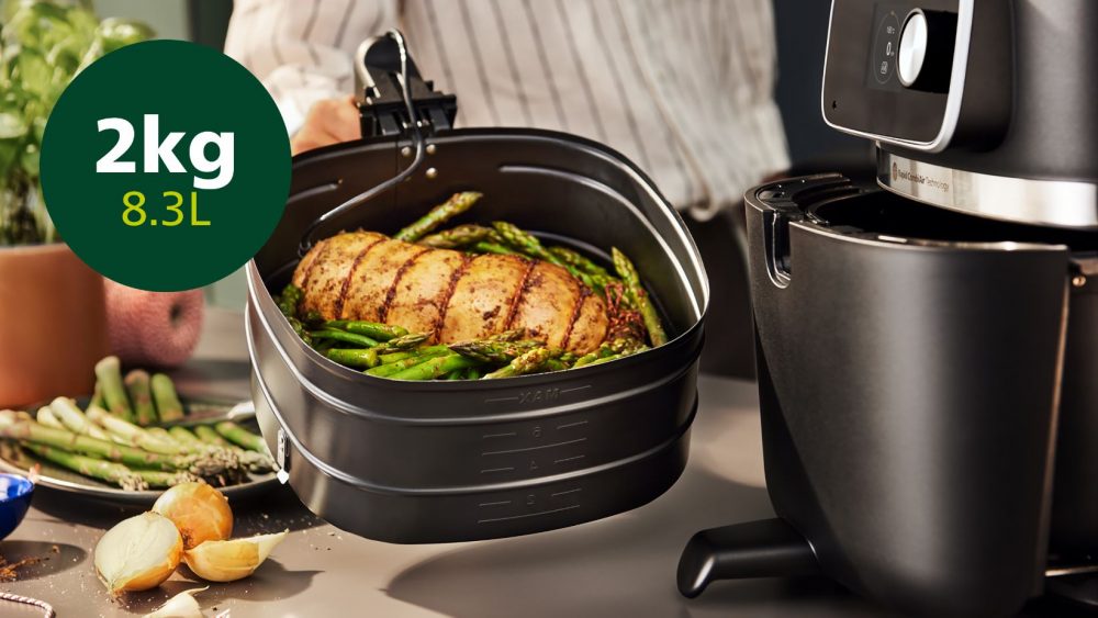 A person holding the Philips 7000 XXXL Airfryer tray, with a logo next to it indicating it has a 2kg capacity.