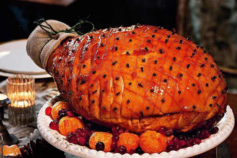 Maple Glazed Ham plated with mandarins and cranberries.