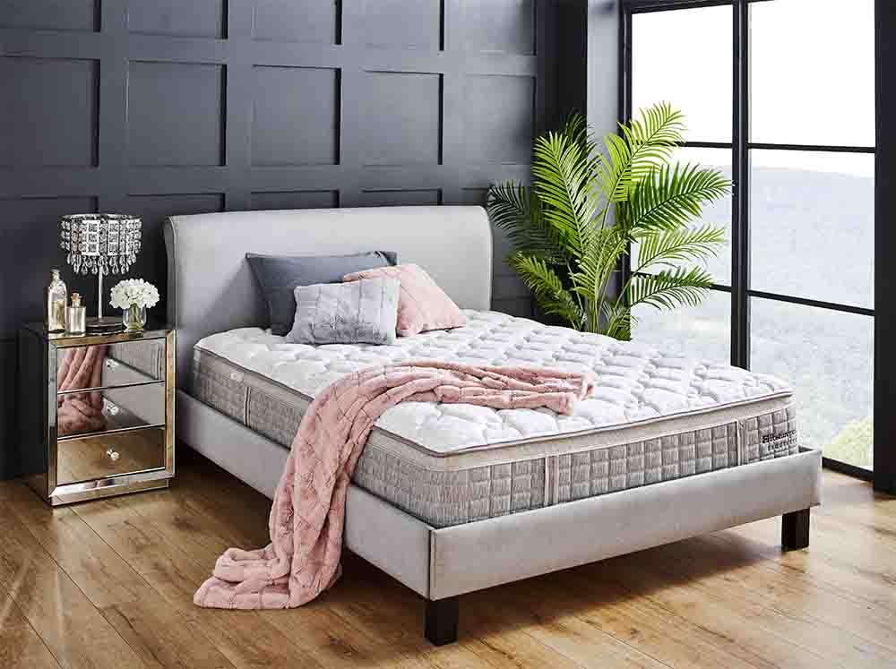 The Sealy Posturepedic Hammond Mattress with a throw on top.