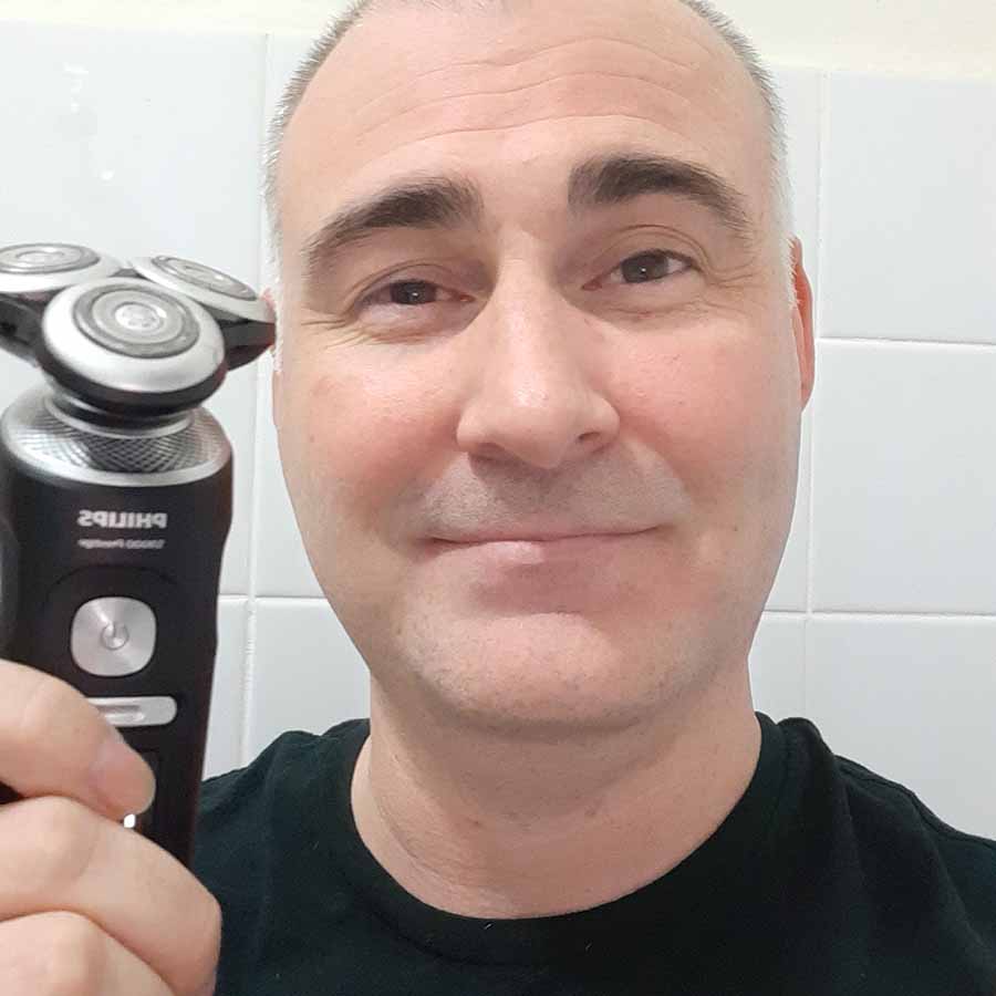 Our reviewer holding the Philips Series 9000 Shaver after shaving his face with it.