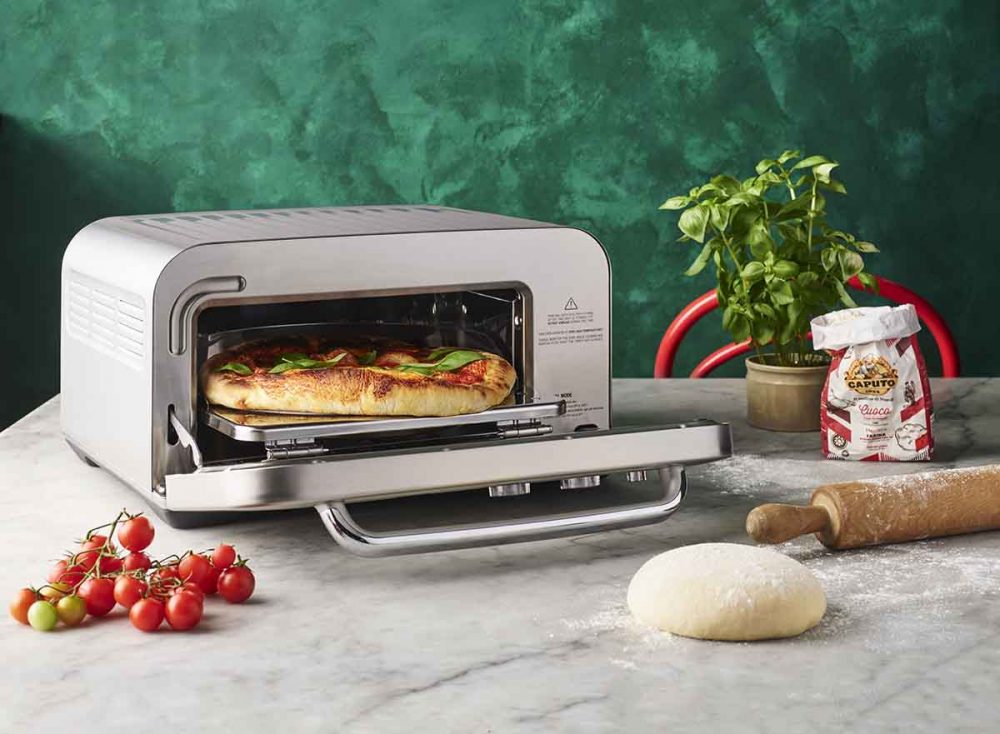 The Smart Oven Pizzaiolo Pizza Oven by Breville cooking a pizza.