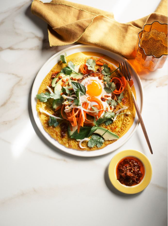 Turmeric & coconut breakfast pancake with avocado, coriander, bean shoots, fried egg & sambal.