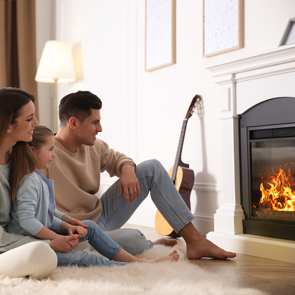 Family gathered in front of a glowing electric fireplace in a warmly lit living room